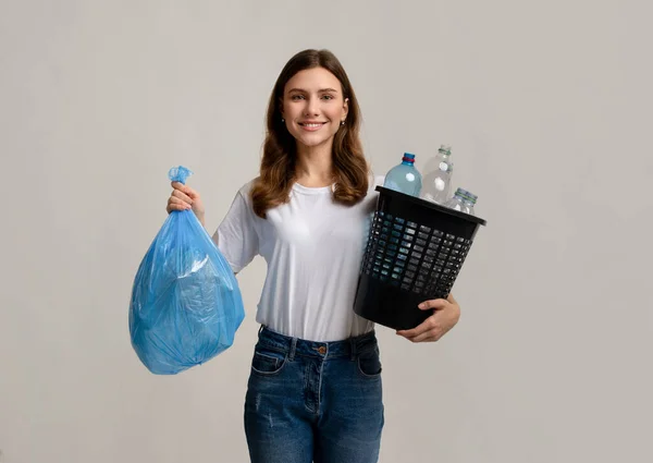Atık Ayırma. Plastik şişelerle dolu çöp poşeti ve kova taşıyan kadın. — Stok fotoğraf
