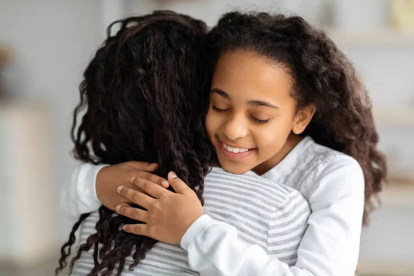 Αξιολάτρευτη σγουρή μαύρη μαθήτρια που αγκαλιάζει τη μαμά της — Φωτογραφία Αρχείου