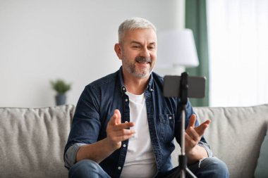 Gülümseyen kıdemli adam vlogger evden yayın yapıyor