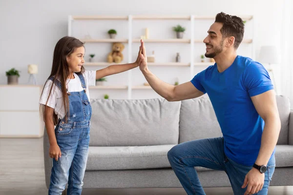 Padre e figlia che danno il cinque in salotto — Foto Stock