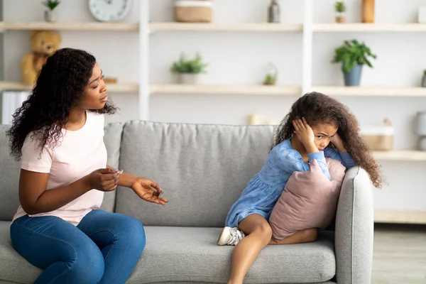 Conflicto de madre hija. Joven madre negra tratando de hablar con su pequeño hijo ofendido en casa — Foto de Stock