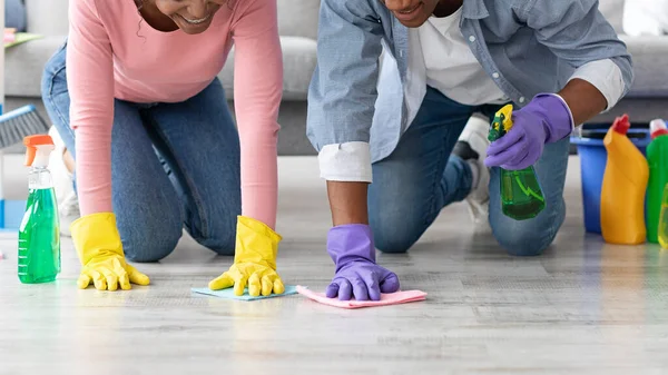 Onherkenbare zwarte man en vrouw schoonmaken vloer in de woonkamer — Stockfoto