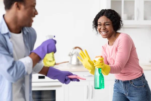 Giocoso afro-americani amanti divertirsi durante la pulizia kicthen — Foto Stock