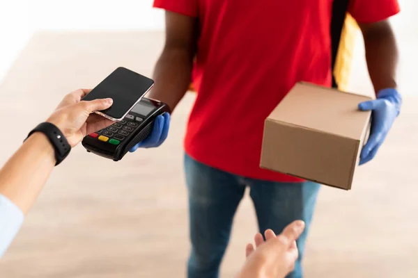 Schwarzer Mann hält Kassenautomaten-Kunde beim Bezahlen mit Smartphone — Stockfoto
