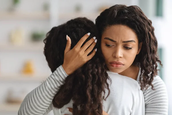 Preocupado jovem mãe negra confortando sua filha chorando — Fotografia de Stock