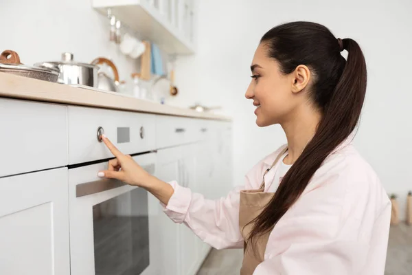 Mulher usando fogão cozinhar alimentos na cozinha — Fotografia de Stock