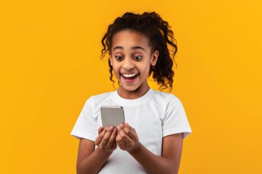 Stüdyoda cep telefonu kullanan heyecanlı zenci kız.