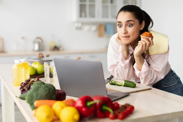 Surpreendido mulher espantada assistindo filme usando laptop e comer — Fotografia de Stock