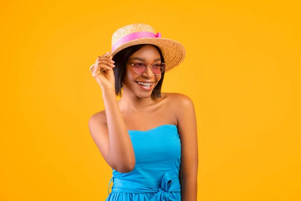 Portrait of charming black woman in casual outfit ready for fun summer holidays on orange studio background — Stock Photo, Image
