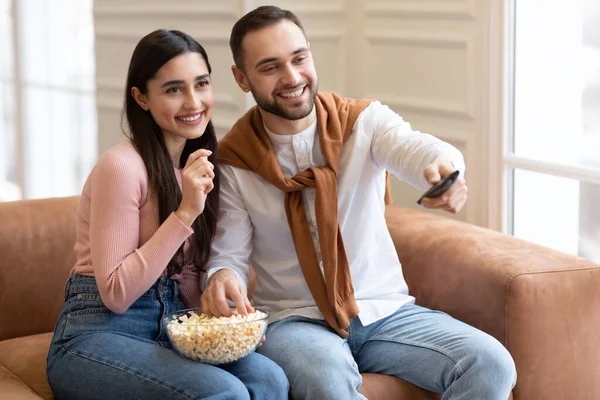 Αραβικό ζευγάρι βλέποντας ταινία στην τηλεόραση τρώει ποπ κορν στο σπίτι — Φωτογραφία Αρχείου