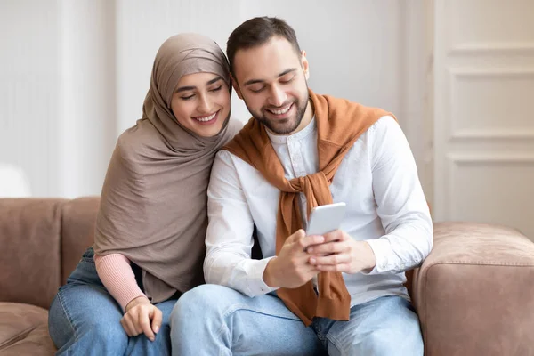 Ближневосточные супруги просматривают Интернет в помещении — стоковое фото