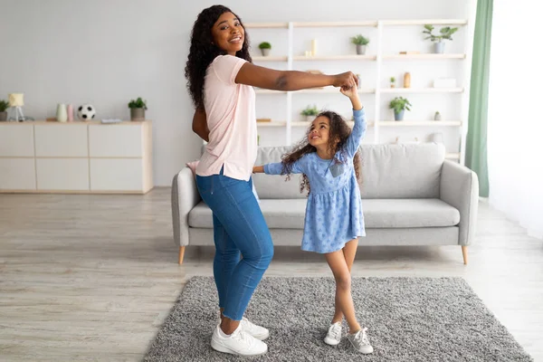 Longitud completa de madre afroamericana bailando música con su linda hijita en casa —  Fotos de Stock