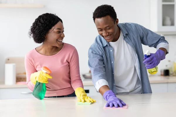 Χαρούμενο μαύρο ζευγάρι καθαρίζει την κουζίνα και διασκεδάζει — Φωτογραφία Αρχείου