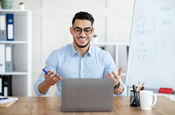 Online-Sprachschule. Arabische männliche Englischlehrerin erteilt Fernunterricht am Laptop im häuslichen Büro — Stockfoto