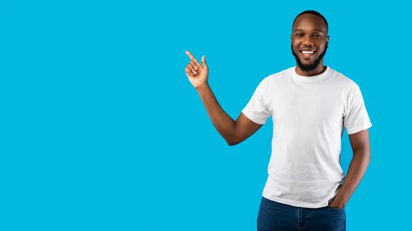 Black Man Pointing Finger Aside Smiling To Camera, Blue Background — Stock Photo, Image