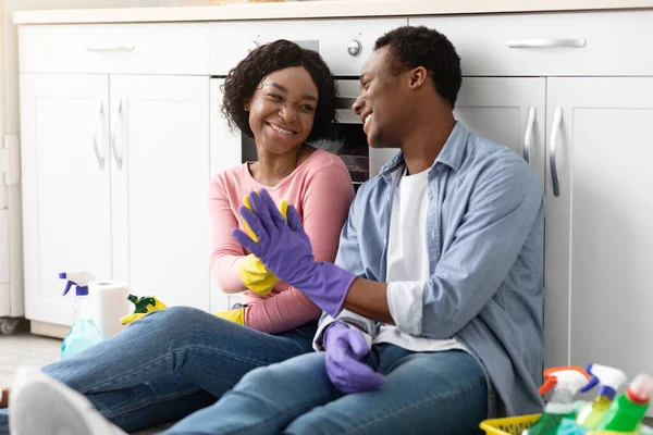 Smiling black man and woman house-keepers giving high five