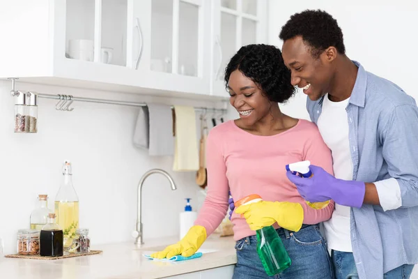 Glada svarta älskare städa köksmöbler tillsammans — Stockfoto