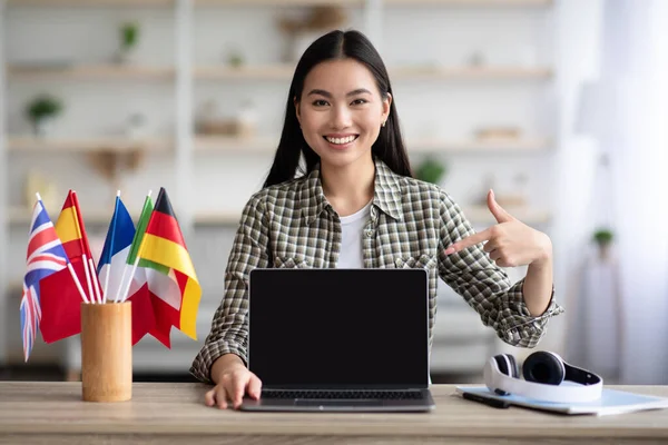 Mutlu Asyalı kadın boş ekranlı dizüstü bilgisayar gösteriyor — Stok fotoğraf