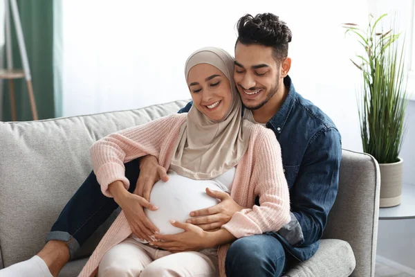 Feliz Esperanza. Esposo árabe cariñoso abrazando y tocando vientre de esposas embarazadas — Foto de Stock