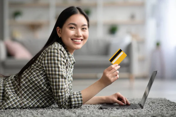 Happy woman using laptop and credit card at home — Stock Photo, Image