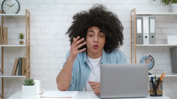 Profesor negro emocional en el ordenador portátil que explica la lección en línea en interiores — Vídeo de stock