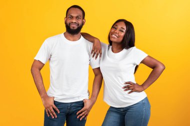 Stüdyoda Afrikalı Amerikalı kadın erkeğinin omzuna yaslanıyor.