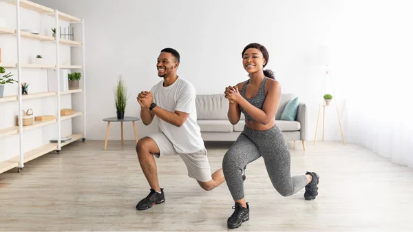 Fitness domestico. Lunghezza completa della coppia nera motivata che fa affondi in soggiorno, design banner — Foto Stock