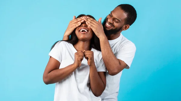 Черный мужчина удивляет свою женщину, закрывая ей глаза — стоковое фото