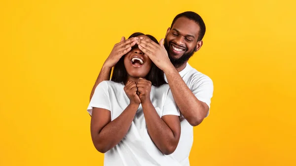 Siyah adam kadınına sürpriz yapıyor, gözlerini kapatıyor. — Stok fotoğraf