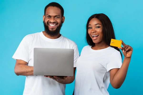 Famiglia nera con computer e carta di credito allo studio blu — Foto Stock