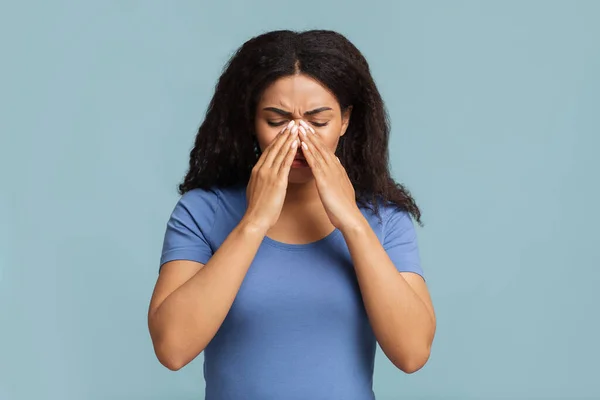 Jovem negra tocando sua ponte nasal, sofrendo de rinite, fundo cinza — Fotografia de Stock