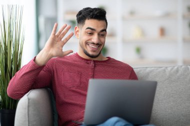 Neşeli Orta Doğulu adam arkadaşlarıyla video konferansı yapıyor.
