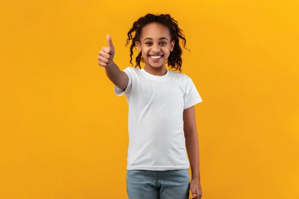 Ευτυχισμένο μαύρο κορίτσι που χύνει τους αντίχειρες και χαμογελά — Φωτογραφία Αρχείου