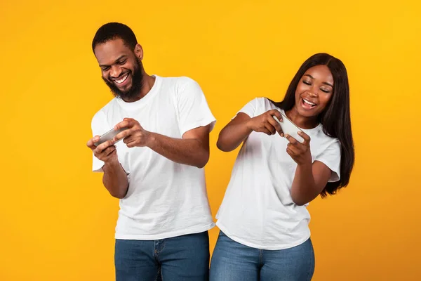 Cep telefonu kullanan, oyun oynayan Afrikalı Amerikalı çift. — Stok fotoğraf