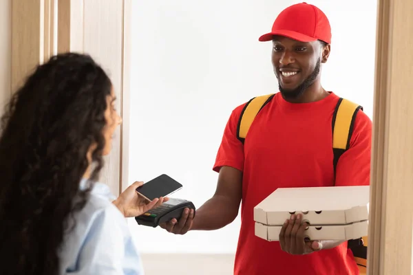 Schwarzer Zusteller mit Pizzaschachtel und POS-Terminal — Stockfoto