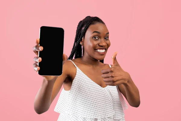 디자인을 위해 흉내를 내며 핸드폰을 들고 핑크 색 배경 위에 엄지손가락을 보이는 행복 한 흑인 여성 — 스톡 사진