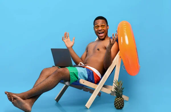 Emocional chico negro sentirse sorprendido delante de la computadora portátil, relajarse en el sillón, aprender acerca de la venta en línea enorme —  Fotos de Stock