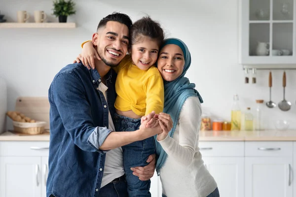 Boldog muszlim család három kicsi lánya pózol a konyhában — Stock Fotó