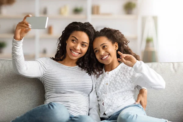Leende svart kvinna och hennes dotter tar selfie tillsammans — Stockfoto