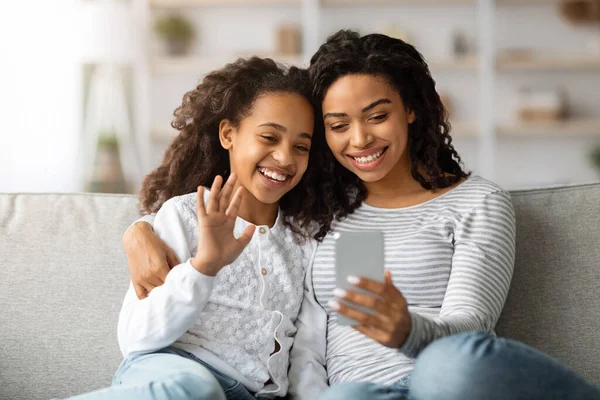 Glada svart mor och dotter som har videosamtal via smartphone — Stockfoto