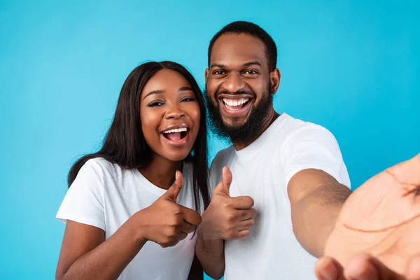 Glad afro par tar selfie gestikulerande tummen upp och ler — Stockfoto