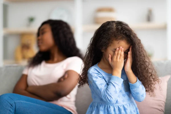 Niña negra llorando, teniendo conflicto con su enojada madre cansada en casa, espacio libre — Foto de Stock