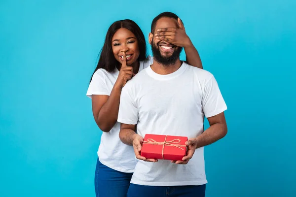 Szczęśliwy czarny kobieta co romantyczny niespodzianka dla chłopak dając pudełko — Zdjęcie stockowe
