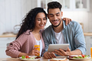 Sabah keyfi. Arap Eşler Kahvaltı Yapıyor ve Mutfakta Dijital Tablet Kullanıyor