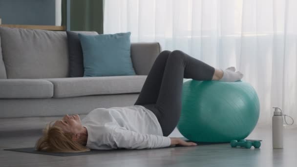 Sénior feminino fazendo Pilates Exercício com Fitball em casa — Vídeo de Stock