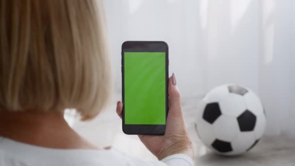緑の画面で携帯電話を保持するスポーティシニア女性屋内,バックビュー — ストック動画