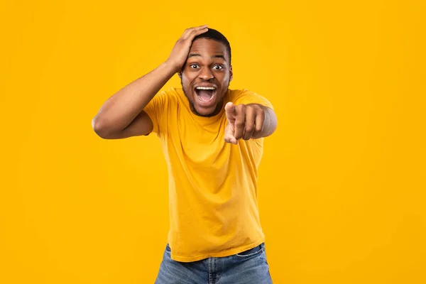 Excitado Africano Guy apontando o dedo para a câmera rindo, fundo amarelo — Fotografia de Stock