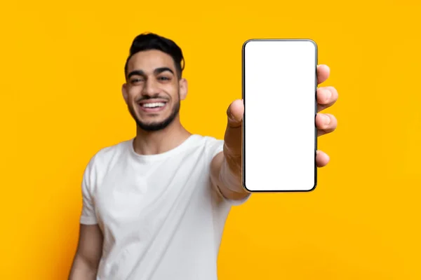 Homem feliz do Oriente Médio mostrando smartphone com tela vazia — Fotografia de Stock