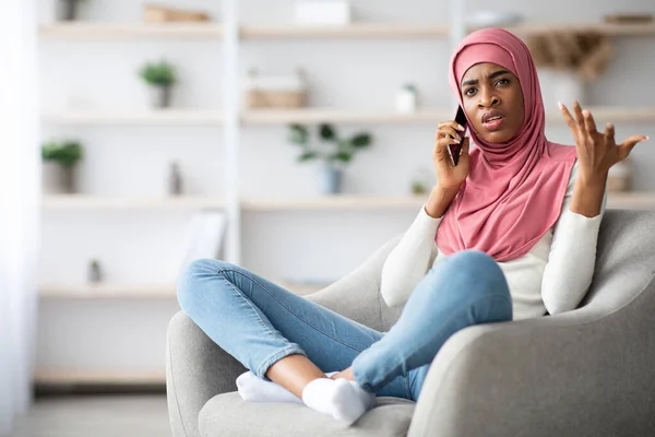 Preoccupato nero musulmano donna in hijab parlando su cellulare a casa — Foto Stock