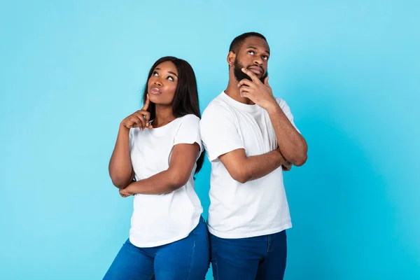 Negro hombre y mujer pensando en fondo azul — Foto de Stock